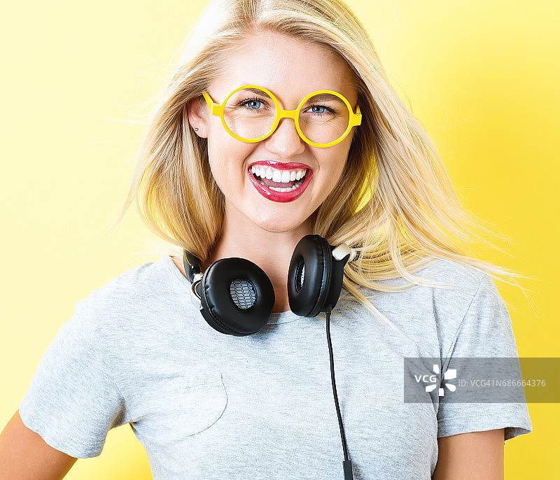 快乐的年轻女子戴着耳机图片素材