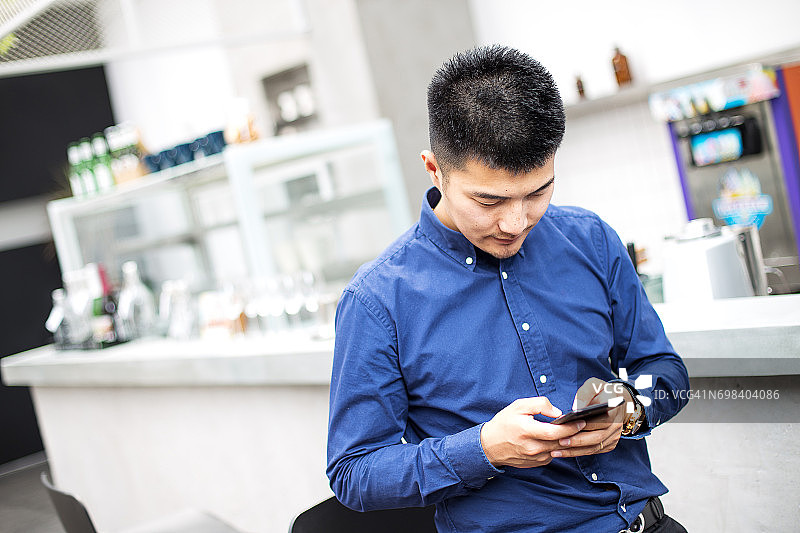 年轻的亚洲男子使用手机图片素材