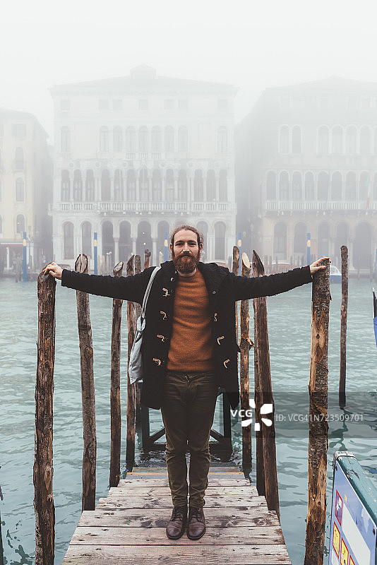 中年男子的肖像在朦胧的运河码头，威尼斯，意大利图片素材