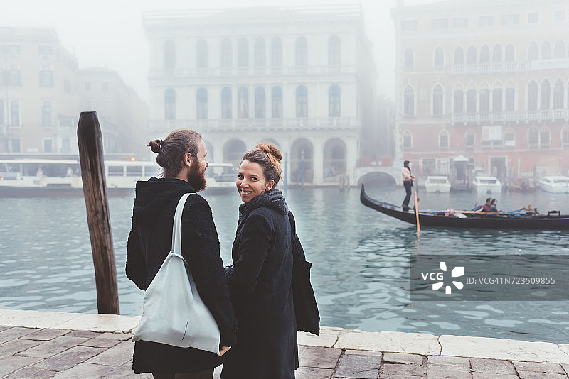在朦胧的运河海滨，威尼斯，意大利夫妇的后视图图片素材