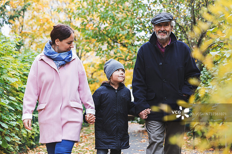 快乐的老人和曾孙和女儿秋天在公园散步图片素材