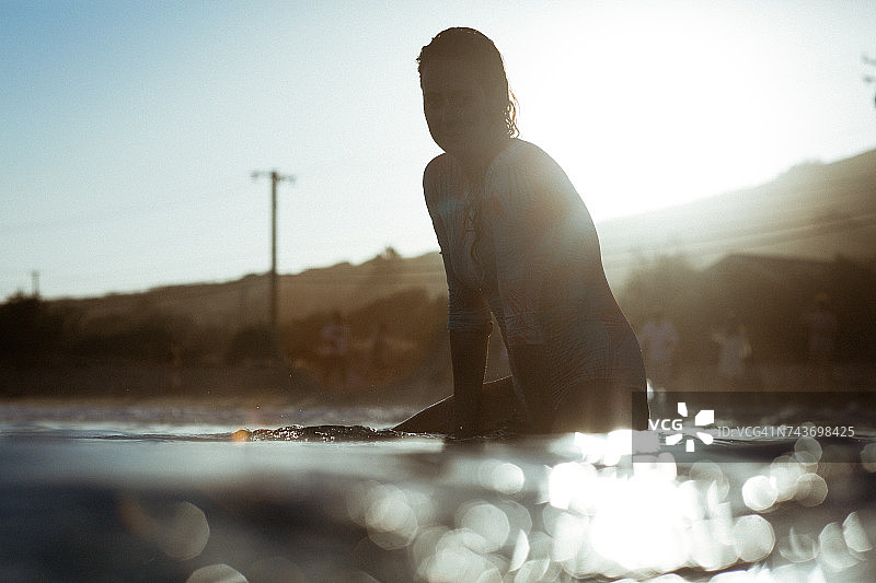 一个女人坐在冲浪板上的剪影，马里布，加州，美国，美国图片素材