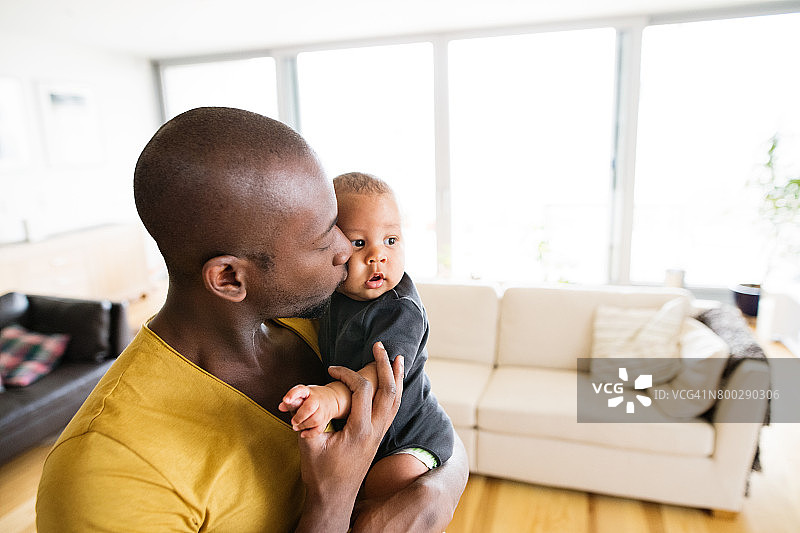 一位年轻的美国黑人父亲抱着他的小儿子图片素材