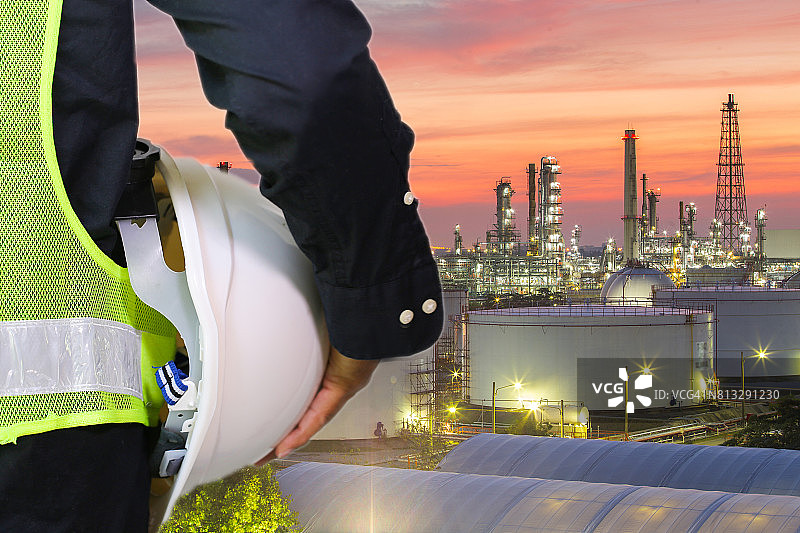 一名戴着白色安全帽的工程人员站在重石化工业炼油厂建筑结构前图片素材