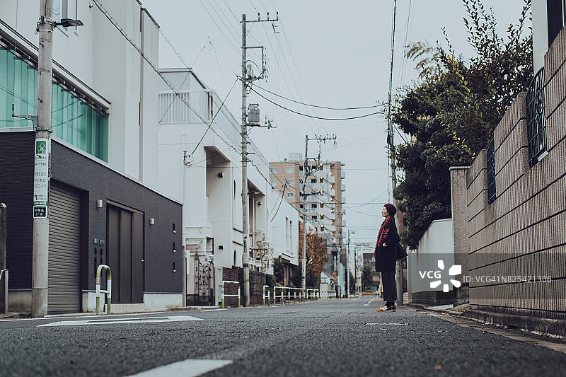 走在日本当地城市街道上的年轻女子图片素材