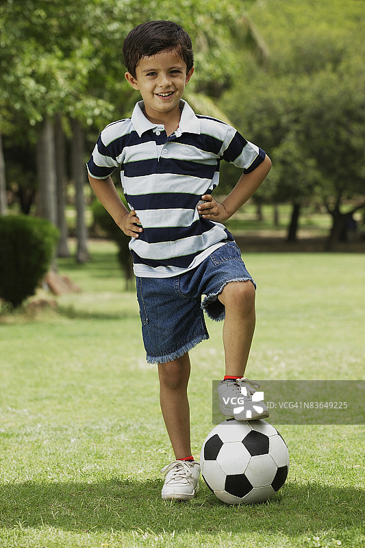 小男孩用脚踢足球图片素材