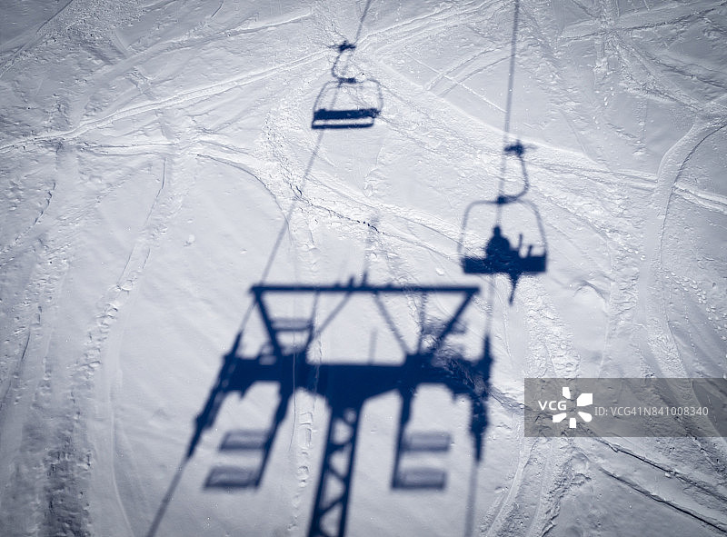 一个滑雪者坐在滑雪缆车的影子图片素材