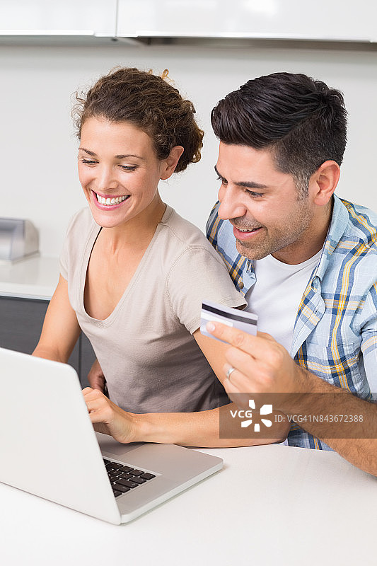 快乐的夫妇一起用笔记本电脑在网上购物图片素材