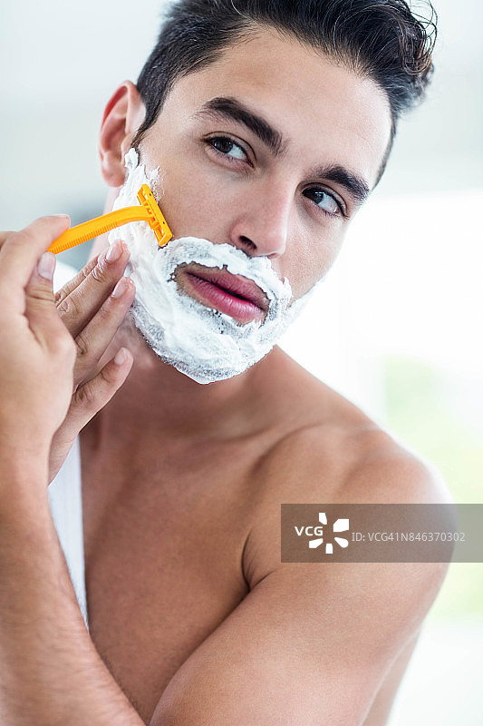 英俊的男人刮他的胡子图片素材