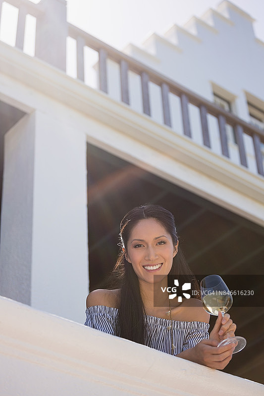 微笑的女人拿着白葡萄酒杯在餐厅图片素材