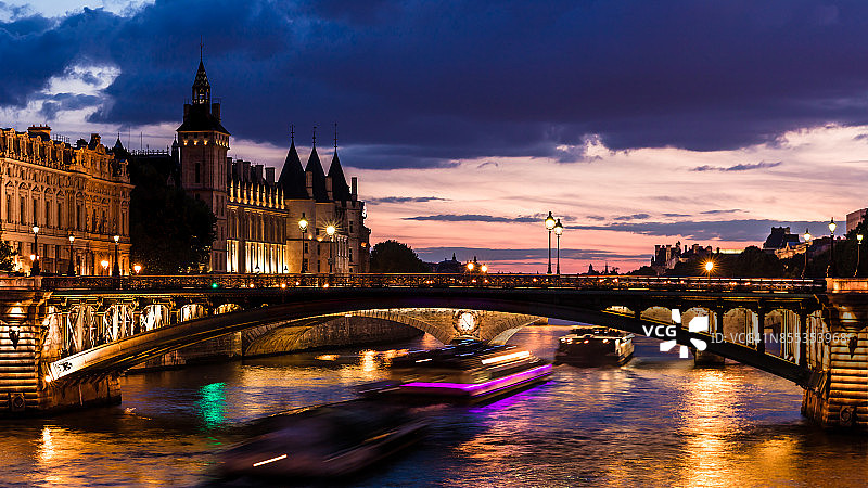 塞纳河上的贡赛杰里城堡和圣母院桥的夜景。法国巴黎图片素材