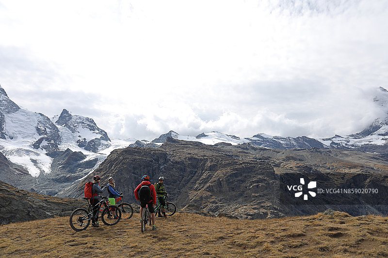 山地自行车手在马特洪峰下面的高山草地上停下来图片素材