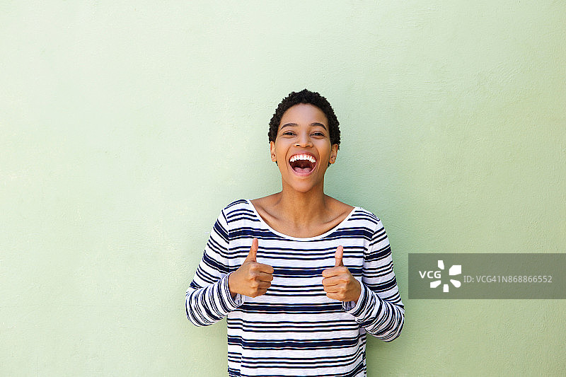 年轻的非洲妇女笑着竖起大拇指图片素材