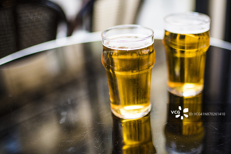 两杯啤酒放在巴黎人的吧台上。图片素材