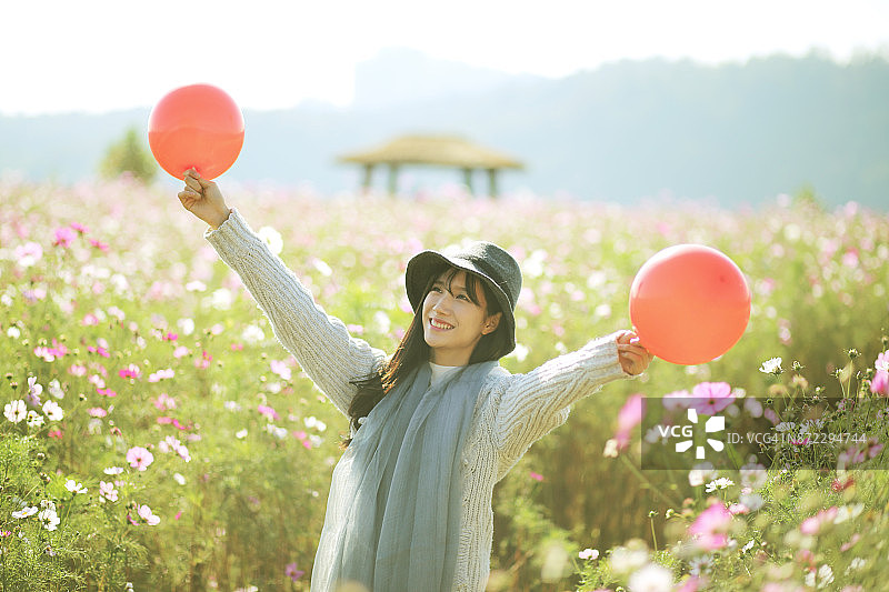 快乐的年轻女子站在宇宙场和气球图片素材
