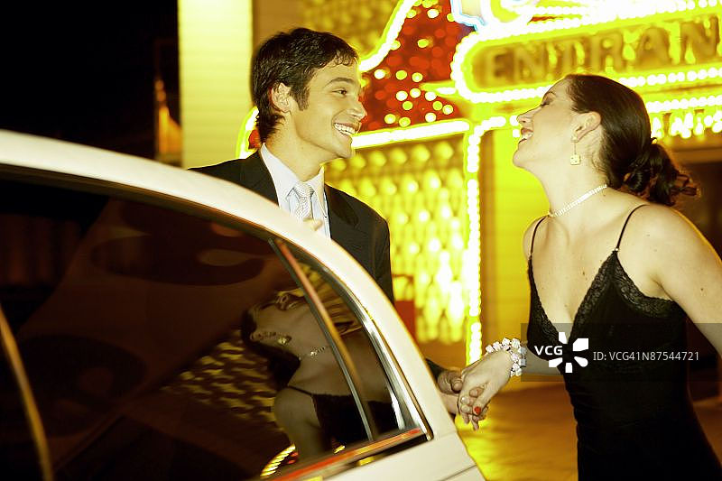 一男一女开着豪华轿车在赌场前图片素材