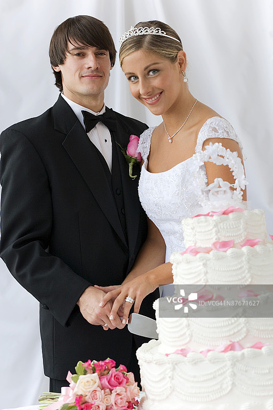 新郎新娘微笑着切婚礼蛋糕图片素材