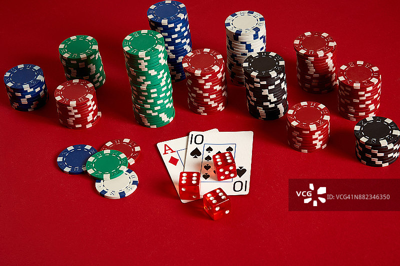 红色背景上的扑克牌和筹码图片素材