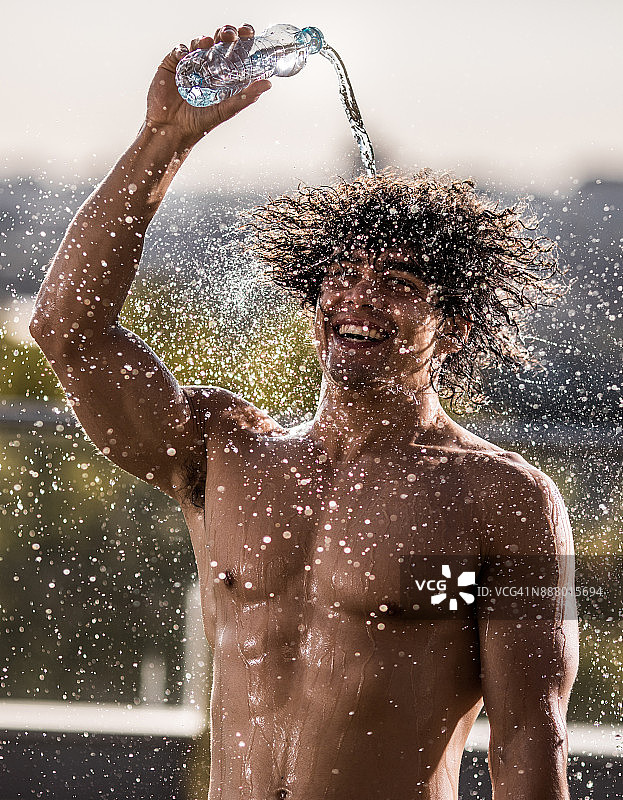 快乐的肌肉发达的运动员刷新自己的新鲜水。图片素材