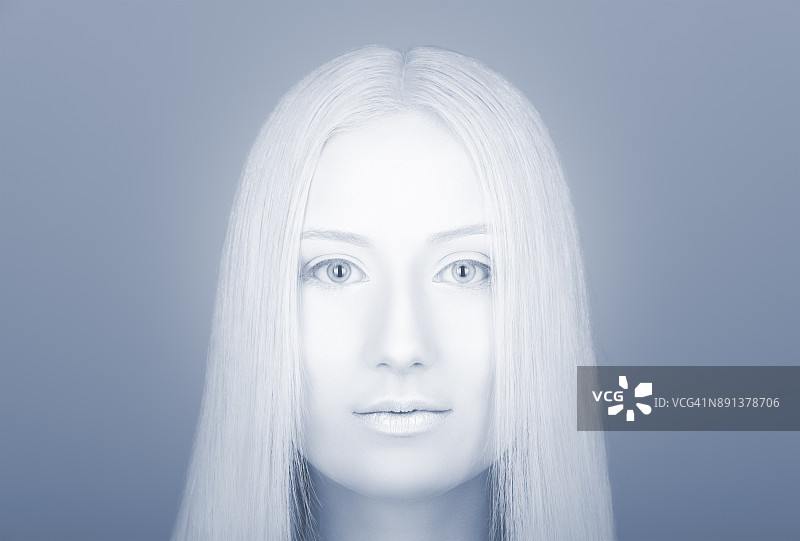 一个年轻女人的脸的苍白色调的美丽肖像。专业的化妆和色彩校正图片素材