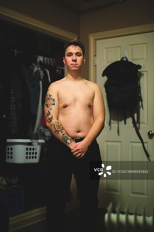 纹身男子在卧室生活方式照片穿衣服图片素材
