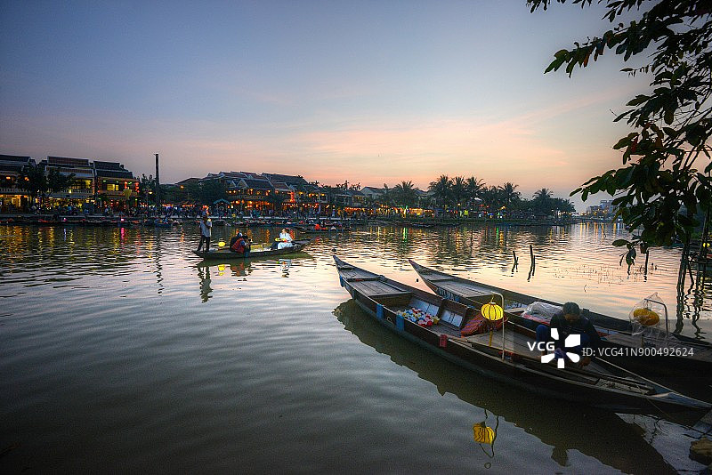 在越南会安的河边，夕阳西下，人们享受着乘船的乐趣。图片素材
