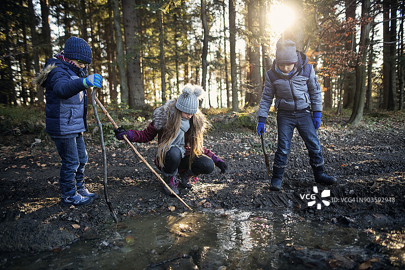 孩子们在冬天玩结冰的水坑图片素材