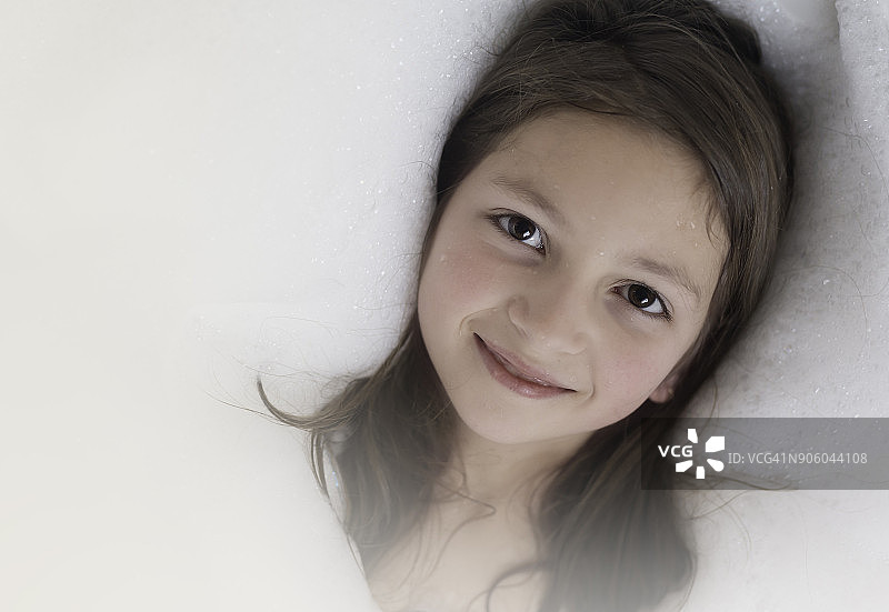 高角度的年轻女孩与棕色头发和棕色眼睛在浴缸图片素材