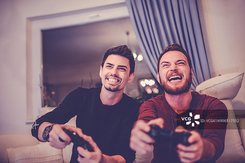 两个兴奋的朋友在玩电子游戏图片素材