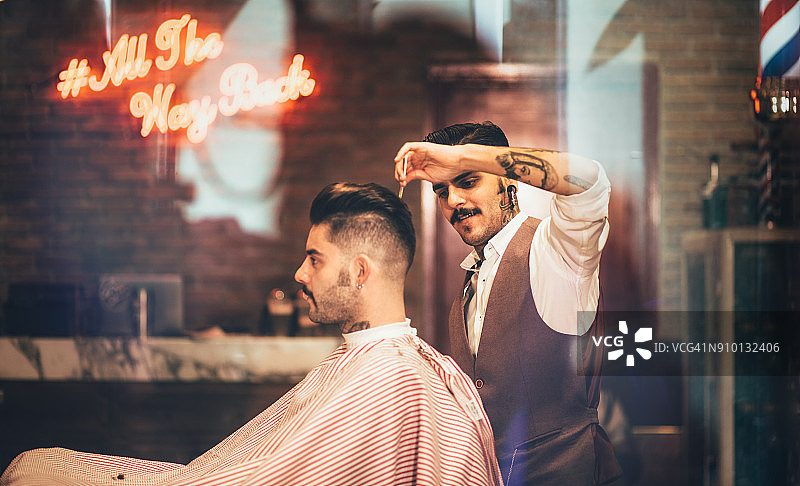 时髦的理发师给时髦的顾客时髦的发型图片素材