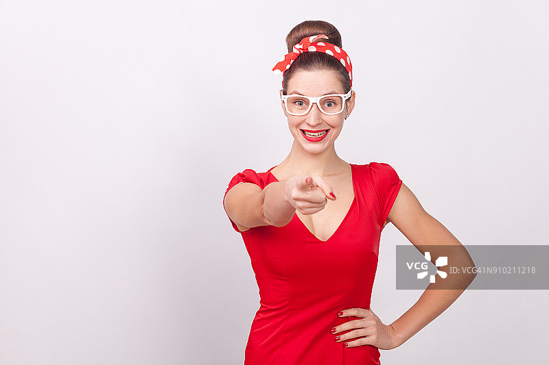 幸福的女人穿着红色的衣服指着手指一个牙齿的微笑图片素材