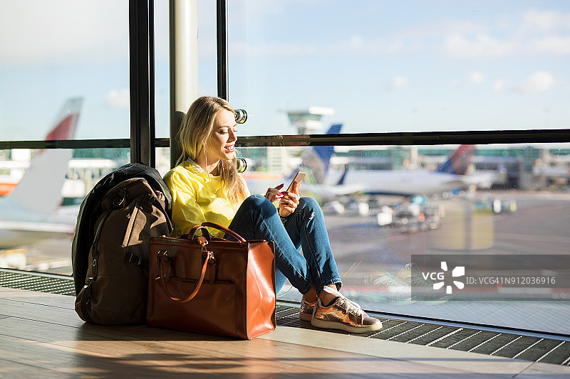 一个女人坐在机场等待她的航班图片素材