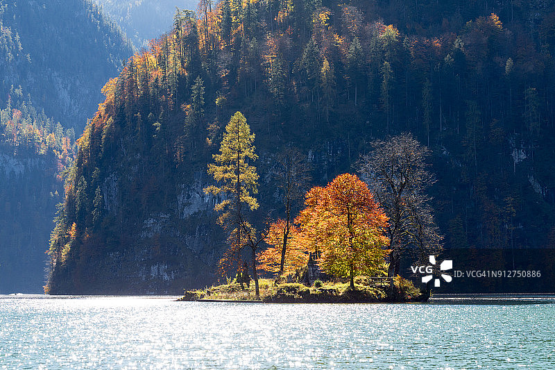 田园诗般的秋景，枝叶茂盛，落叶乔木，湖面映照四周群山图片素材