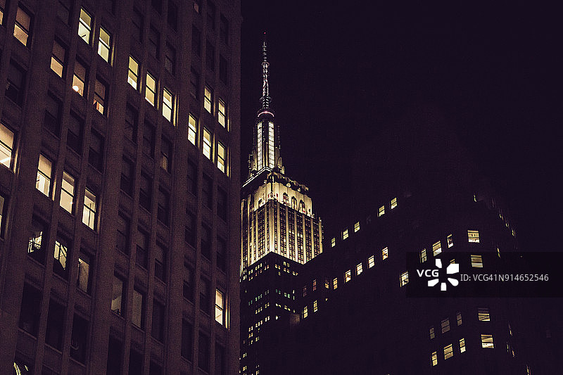 远处的帝国大厦灯光照亮的夜晚。曼哈顿图片素材