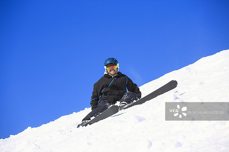 男子滑雪者躺在粉雪中滑雪。在意大利的滑雪胜地Dolomites滑雪。图片素材