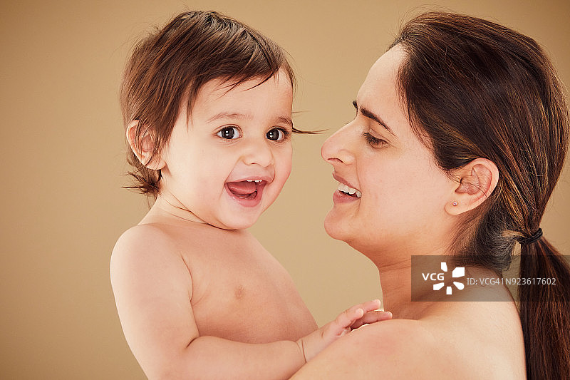 母亲抱着微笑的男婴(11-12个月)图片素材