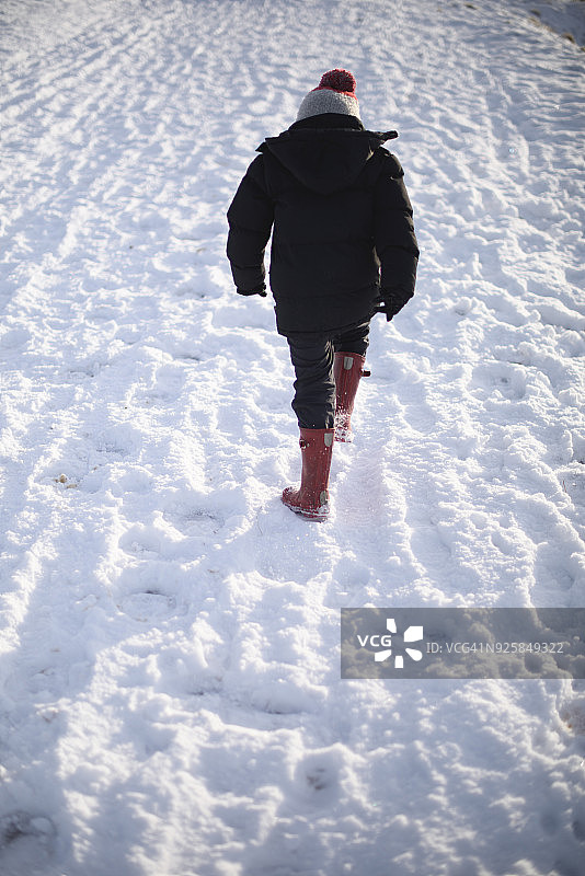 男孩走在雪地里图片素材