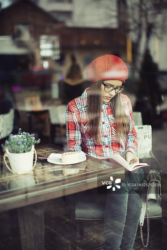 漂亮的年轻女子坐在咖啡店喝茶图片素材