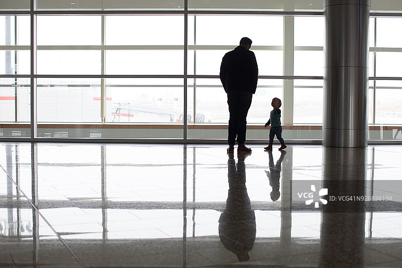 加拿大阿尔伯塔省，机场窗边的父子图片素材