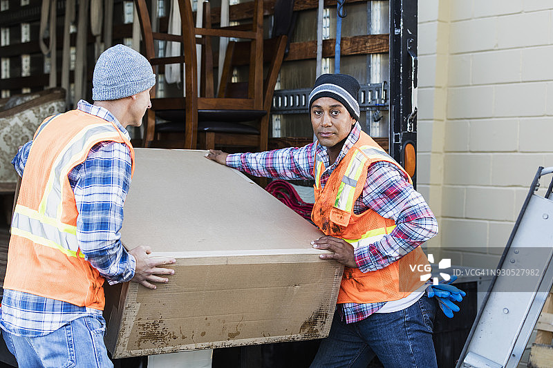 两名工人用卡车搬运大箱子图片素材