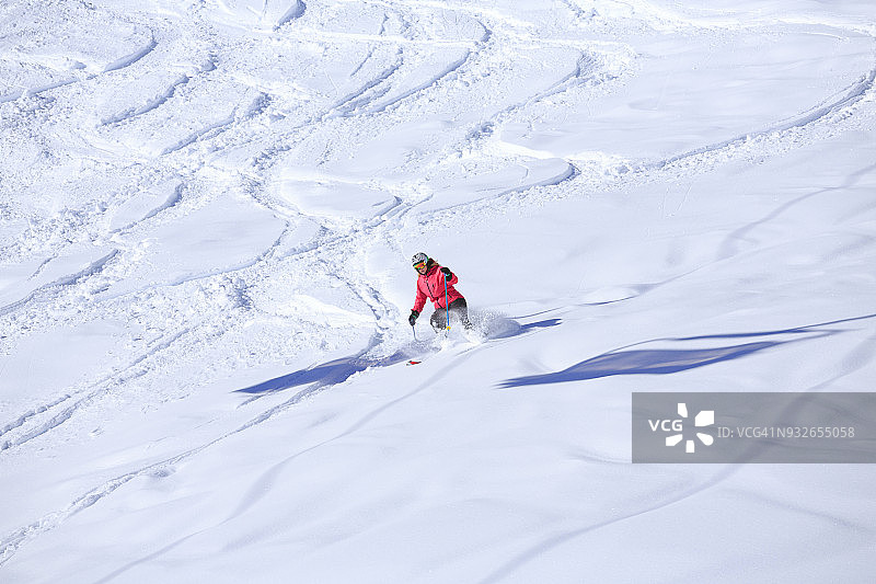 雪上滑雪业余冬季运动女子滑雪者在粉雪中滑雪。在意大利阳光明媚的滑雪胜地Dolomites滑雪。图片素材