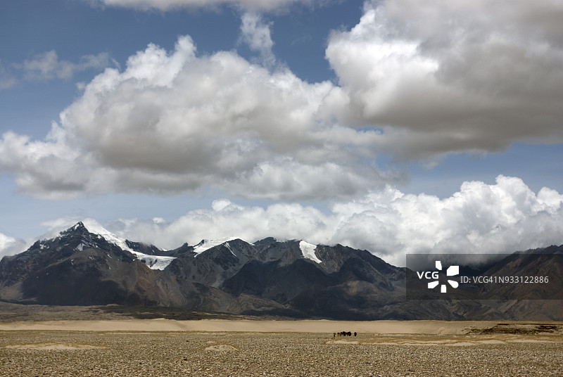 驱车前往西藏定日，经过白雪皑皑的高山和空旷的平原。图片素材