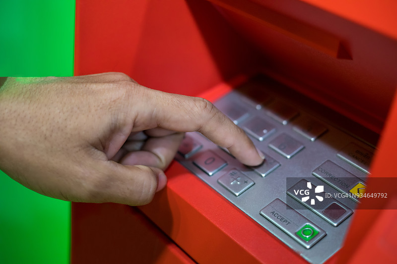 一名男子用手输入ATM机或银行的密码图片素材