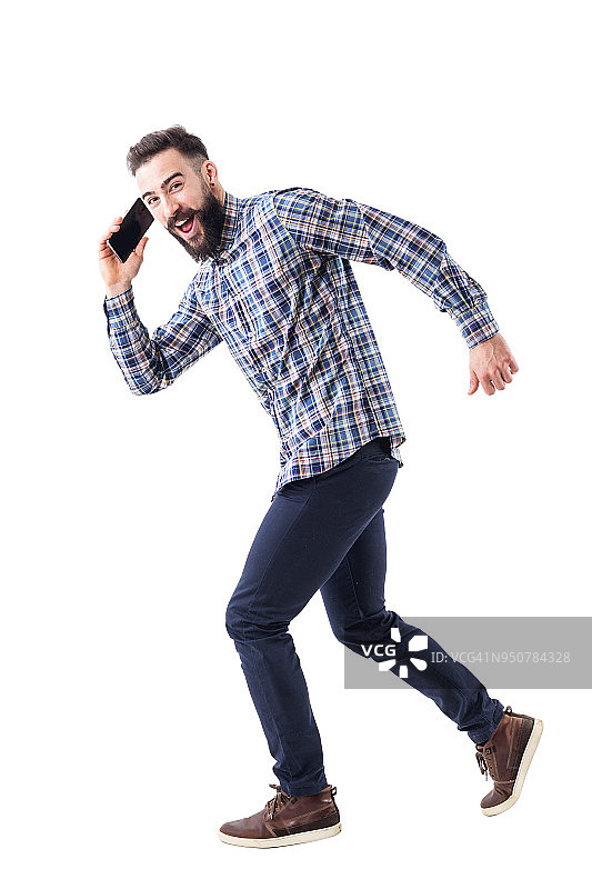 年轻的大胡子商人一边跑一边打手机。图片素材