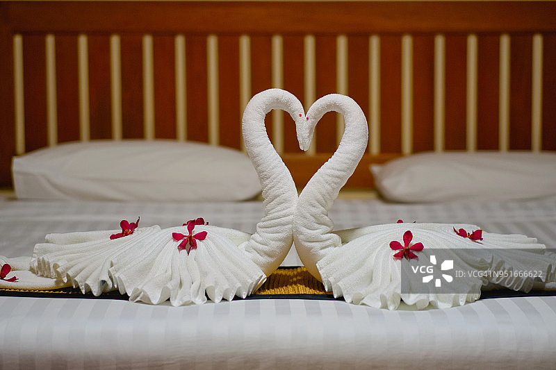 现代卧室的室内设置在白色的毯子和木床上为蜜月床。图片素材