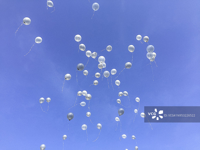 五颜六色的气球在蓝色的天空中飞走了。婚礼仪式。图片素材