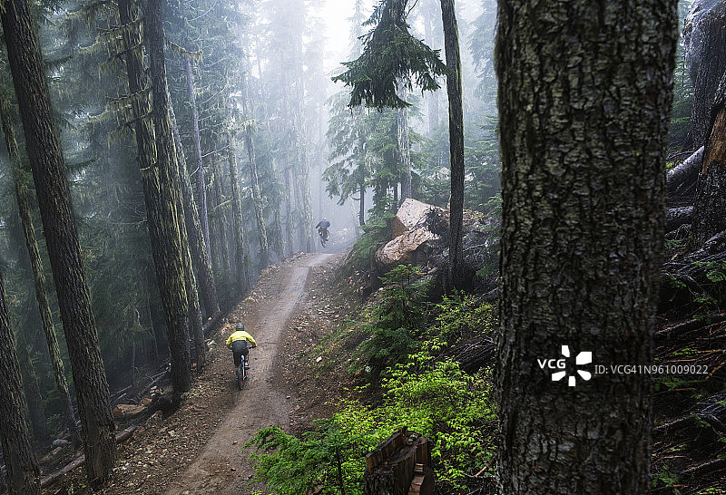 高角度的男性朋友山地自行车在森林图片素材