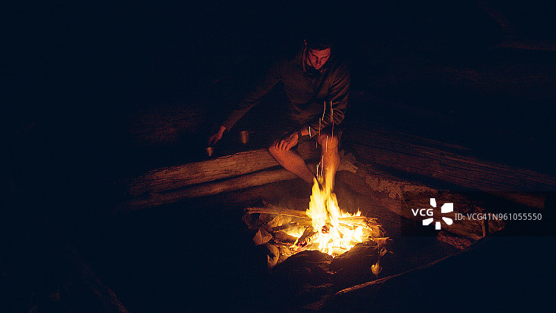 晚上坐在篝火旁的男人图片素材