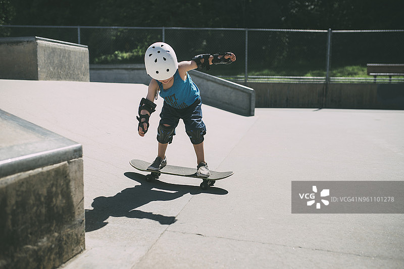 整个长度的男孩滑板在滑板公园在夏天图片素材