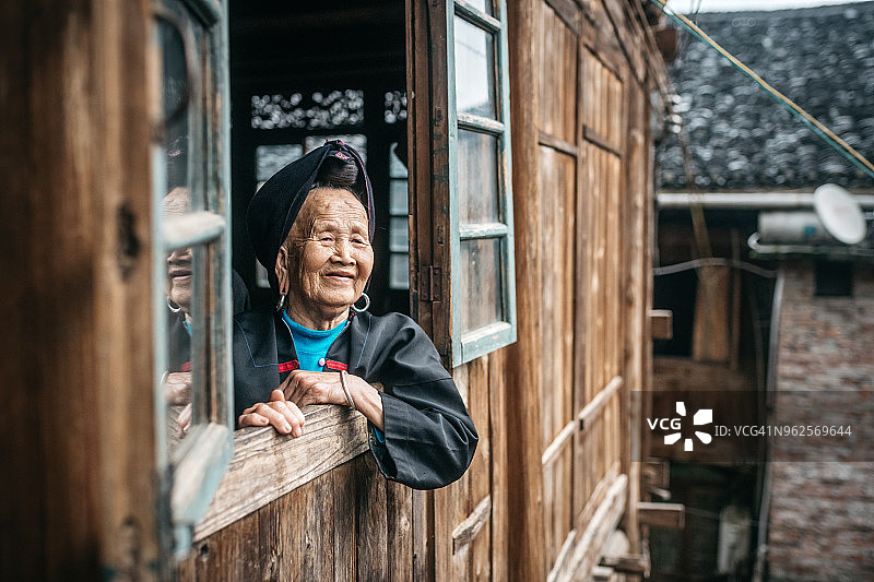 年迈的少数民族中国妇女望着窗外图片素材